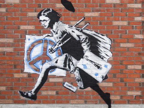 Street-Art-Kunstwerk. Ein Mädchen rennt von rechts nach links. Sie hat Malutensilien dabei und trägt ein Bild mit Peach-Symbol in der Hand.