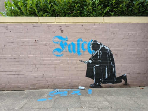 Street-Art-Kunstwerk. Eine Sherlock-Holmes untersucht Fußspuren vor einer Mauer.